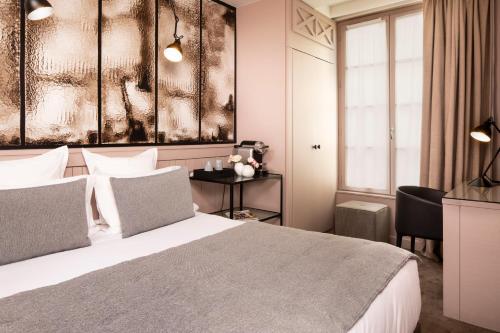 a hotel room with a bed and a window at Hôtel Hélios Opéra in Paris