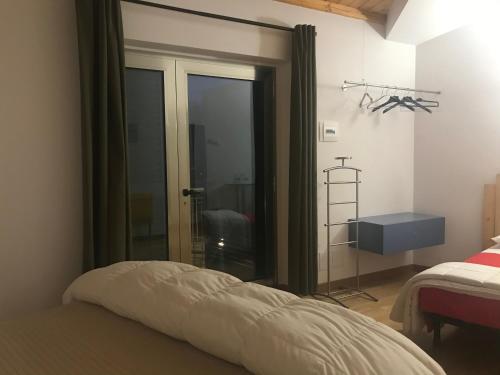 a bedroom with a bed and a sliding glass door at B&B Oasi Vetoio in LʼAquila
