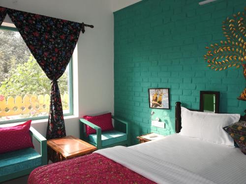 a bedroom with a bed and a green wall at Coral Country Homestay in Agra