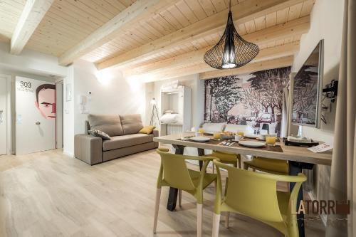 een eetkamer en een woonkamer met een tafel en stoelen bij La Torre Boutique Apartamentos in Teruel