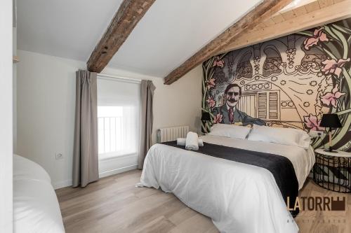 a bedroom with two beds and a mural on the wall at La Torre Boutique Apartamentos in Teruel