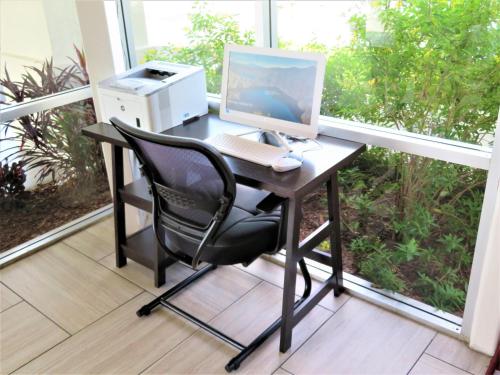 a desk with a computer and a printer on a balcony at Smart Stay Inn - Saint Augustine in Saint Augustine