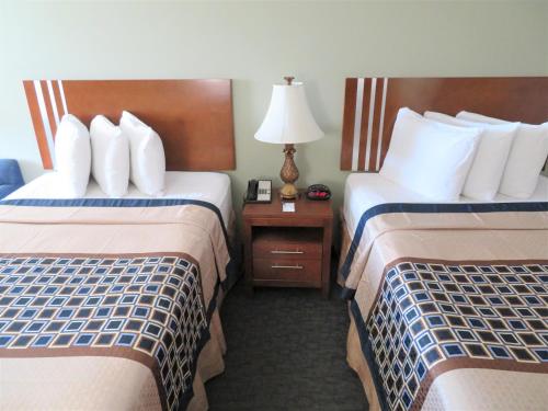 a hotel room with two beds and a table with a lamp at Smart Stay Inn - Saint Augustine in Saint Augustine