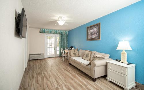a living room with blue walls and a couch at Island Sun Inn & Suites - Venice, Florida Historic Downtown & Beach Getaway in Venice