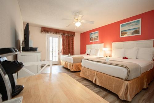 a hotel room with two beds and a television at Island Sun Inn & Suites - Venice, Florida Historic Downtown & Beach Getaway in Venice