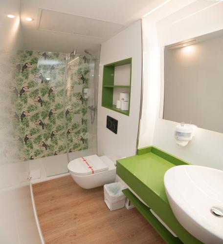 a bathroom with a toilet and a sink and a mirror at Apartamentos Boutique Poniente Playa in San Antonio
