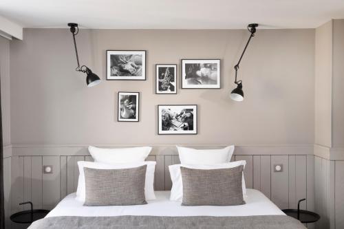- une chambre avec un lit blanc et quatre oreillers dans l'établissement Hôtel Hélios Opéra, à Paris
