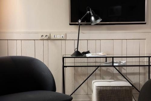 a desk with a lamp and a chair in a room at Hôtel Hélios Opéra in Paris