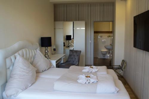 a bedroom with a white bed with flowers on it at Hotel Zum Wersehof in Ahlen