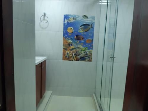 y baño con ducha y una pintura en la pared. en Hermoso Apartamento en Bocagrande-Cartagena, en Cartagena de Indias