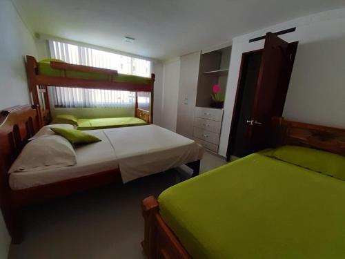 2 camas en un dormitorio con sábanas verdes en Hermoso Apartamento en Bocagrande-Cartagena, en Cartagena de Indias