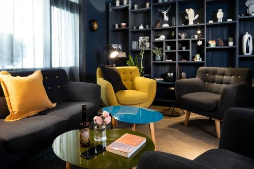 a living room with couches and chairs and a table at Hôtel Hélios Opéra in Paris
