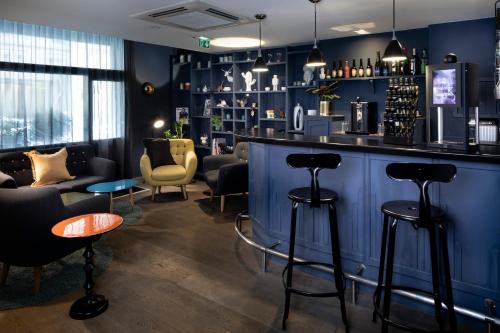 a bar in a room with blue walls and stools at Hôtel Hélios Opéra in Paris