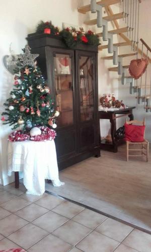 a christmas tree in a room with a staircase at Gîte Rouge Calme et Nature in Allas-Bocage