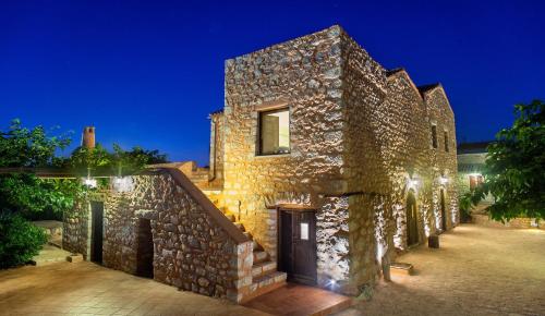 a stone house at night with lights at Guesthouse Toxotis in Pirgos Dhirou