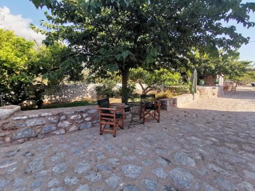 a table and chairs sitting under a tree at Guesthouse Toxotis in Pirgos Dhirou