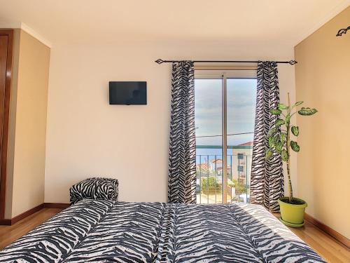 a bedroom with a bed and a large window at Cliff Refuge by LovelyStay in Santa Cruz