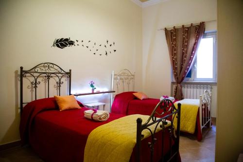 a bedroom with two beds with red and yellow sheets at Casa Primavera in Palermo