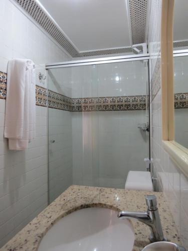 a bathroom with a sink and a shower and a toilet at Hotel Colonial in Ouro Preto