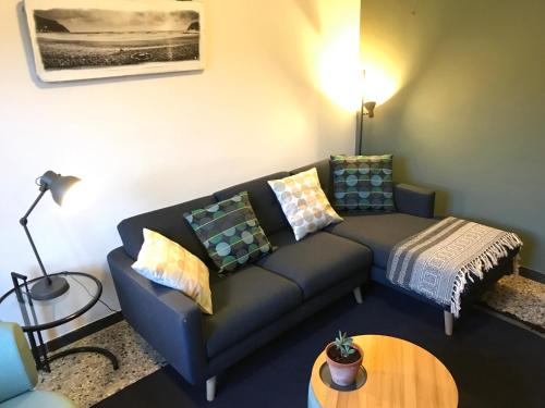 ein Wohnzimmer mit einem Sofa und einem Tisch in der Unterkunft Appartamento Madeleine in Levanto
