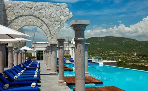una piscina en un complejo con tumbonas azules en Vista Encantada Resort & Spa Residences, A La Carte All Inclusive Optional, en Cabo San Lucas