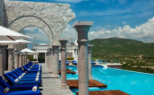 a pool at a resort with blue lounge chairs at Vista Encantada Resort & Spa Residences, A La Carte All Inclusive Optional in Cabo San Lucas