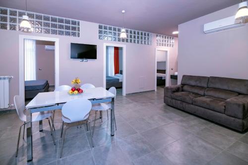 a living room with a couch and a table and chairs at Eracle Hotel in Volla