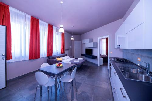 a kitchen and living room with a table and chairs at Eracle Hotel in Volla