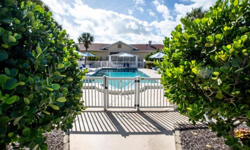 uma piscina com um portão em frente a uma casa em Island Sun Inn & Suites - Venice, Florida Historic Downtown & Beach Getaway em Venice