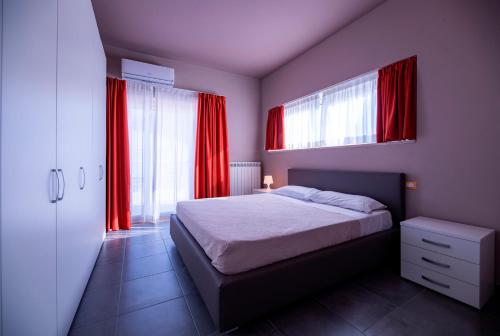 a bedroom with red curtains and a bed in a room at Eracle Hotel in Volla