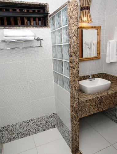 a bathroom with a sink and a mirror at Pousada Ogum Marinho in Praia do Forte