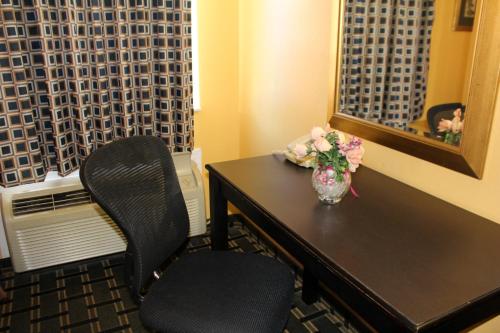 a room with a table and two chairs with a vase of flowers at Magnolia Inn and Suites Southaven in Southaven