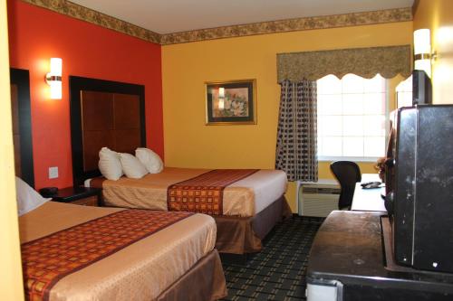 a hotel room with two beds and a window at Magnolia Inn and Suites Southaven in Southaven