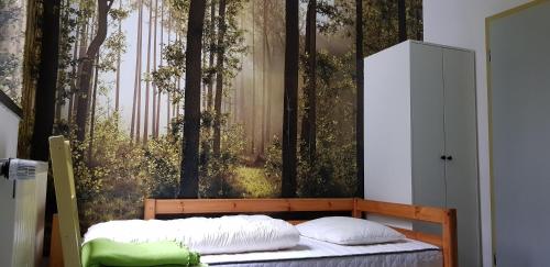 1 dormitorio con 1 cama con pared de bosque en Naturferienhaus Luppbodemühle, en Allrode