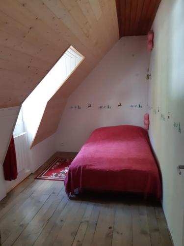 a bedroom with a red bed in a attic at Maison 10 personnes Chez Perrine et Nicolas in La Bourboule