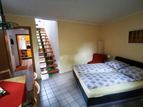 a bedroom with a bed and a staircase in it at Ferienwohnung An der Lottenquelle in Weimar