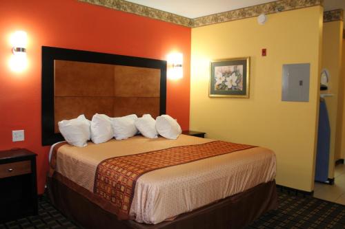 a hotel room with a large bed with white pillows at Magnolia Inn and Suites Southaven in Southaven