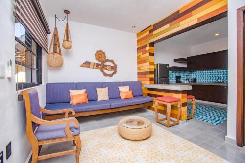 a living room with a blue couch and a table at Condominio Sac Ki in Cozumel
