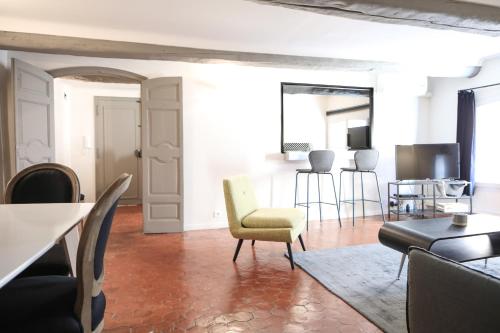 uma sala de estar com uma cadeira amarela e uma mesa em Maison Alberta em Aix-en-Provence
