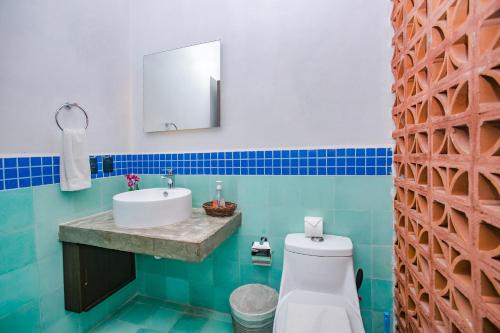 ein Badezimmer mit Waschbecken, Toilette und Spiegel in der Unterkunft Condominio Sac Ki in Cozumel