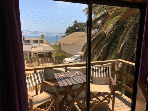 a balcony with a table and chairs and a view of the ocean at Hostal Maitencillo Norte in Maitencillo
