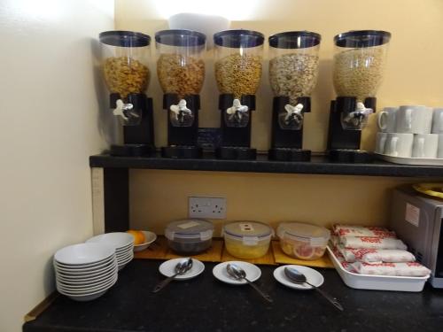 a kitchen counter filled with lots of different types of food at The Gatwick White House Hotel in Horley