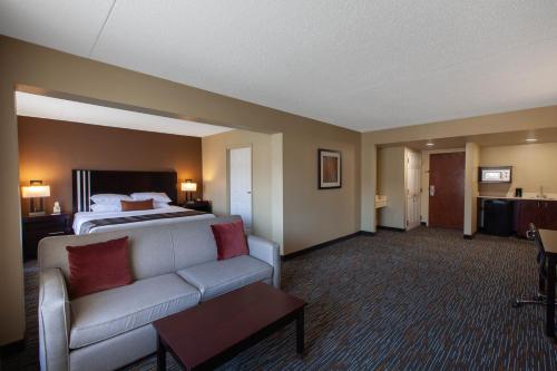 a hotel room with a bed and a couch at Wingate by Wyndham Oklahoma City Airport in Oklahoma City