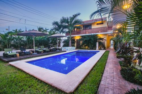 a swimming pool in front of a house at Condominio Sac Ki in Cozumel