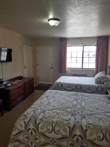 duża sypialnia z 2 łóżkami i oknem w obiekcie Butch Cassidy's Hideout w mieście Circleville