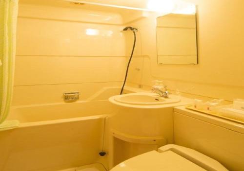 a bathroom with a sink and a toilet and a tub at skyhotel uozu / Vacation STAY 59577 in Uozu