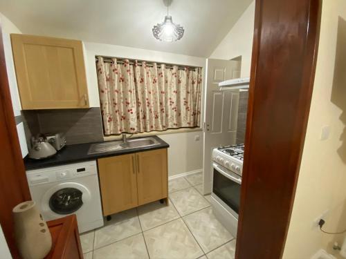 a small kitchen with a sink and a dishwasher at Guest House B&B in Oxford