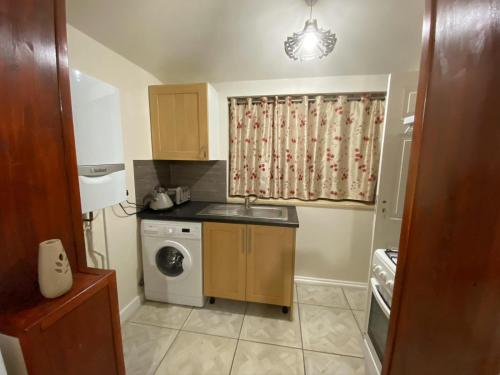una pequeña cocina con fregadero y lavadora en Guest House B&B en Oxford