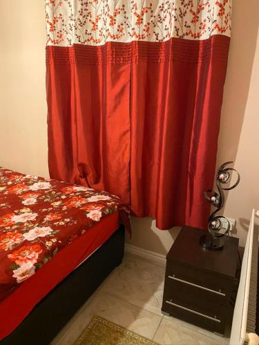 1 dormitorio con cama y cortina roja en Guest House B&B en Oxford