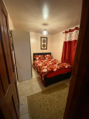um pequeno quarto com uma cama com um edredão vermelho em Guest House B&B em Oxford